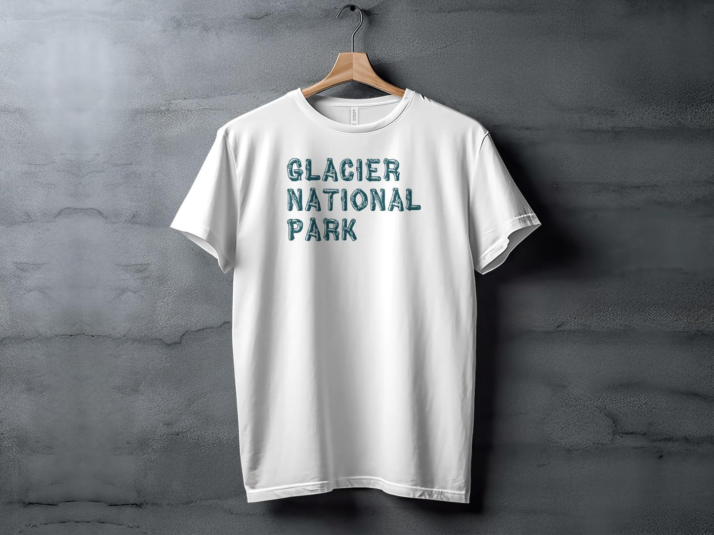 White t-shirt hanging on a hanger with "Glacier National Park" text.